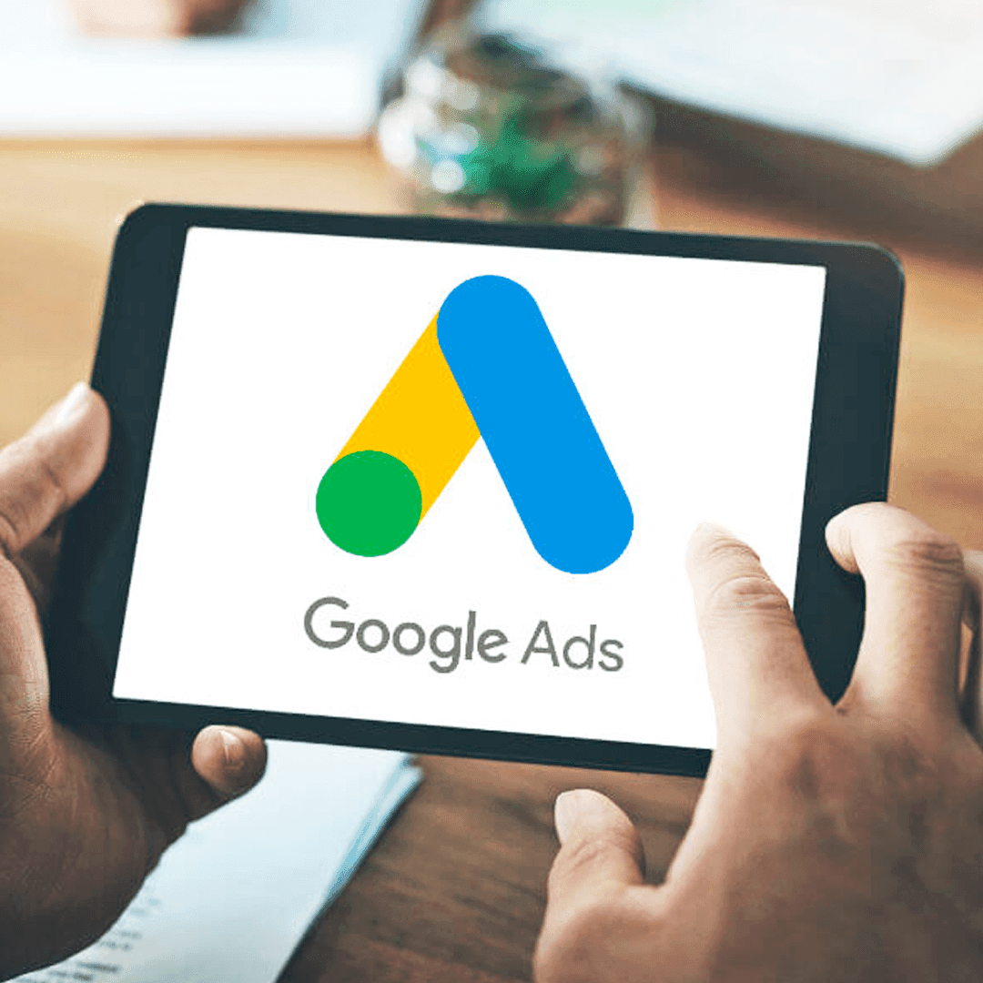 Digital marketer using a tablet to manage Google Ads PPC campaigns and online advertising strategy.